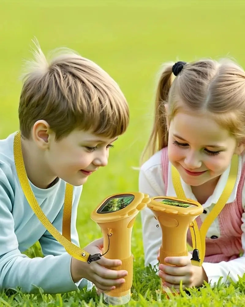 Two kids in the grass with yellow scopes on lanyards